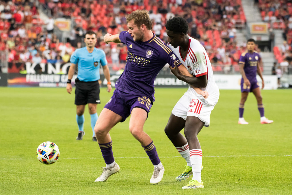 Duncan McGuire #13 (L) of Orlando City SC and Nicksoen Gomis